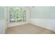 Bedroom with vaulted ceiling, large window overlooking backyard, and neutral carpet at 8840 Woodyhill Rd, Raleigh, NC 27613