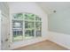 Bedroom with vaulted ceiling, large window overlooking backyard, and neutral carpet at 8840 Woodyhill Rd, Raleigh, NC 27613