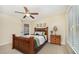 This bedroom features carpeted floors, a ceiling fan, and a dark wood bed with decorative pillows at 8840 Woodyhill Rd, Raleigh, NC 27613