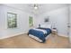 A cozy bedroom with light-colored walls, carpeted floors, ceiling fan and two windows at 8840 Woodyhill Rd, Raleigh, NC 27613