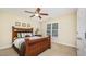 This bedroom features carpeted floors, a ceiling fan, and a dark wood bed with decorative pillows at 8840 Woodyhill Rd, Raleigh, NC 27613