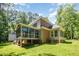 Exterior home view showing a brick and siding design, a screened porch and a well-kept lawn at 8840 Woodyhill Rd, Raleigh, NC 27613