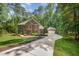 Elegant brick home with attached garage surrounded by mature trees and a driveway at 8840 Woodyhill Rd, Raleigh, NC 27613