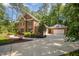 Brick home with attached garage, mature trees and lush landscaping at 8840 Woodyhill Rd, Raleigh, NC 27613
