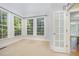Sunroom with carpet, multiple windows, view to outdoors and French door entry at 8840 Woodyhill Rd, Raleigh, NC 27613