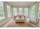 Inviting sunroom filled with natural light, seating area, and multiple large windows at 8840 Woodyhill Rd, Raleigh, NC 27613