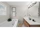 Bright bathroom featuring a soaking tub, wooden cabinets, and neutral colored walls at 9212 Sayornis Ct, Raleigh, NC 27615