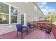 Back deck featuring two blue chairs, a small table, and a red wooden railing at 100 Stratford Lakes # 130, Durham, NC 27713