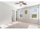 This bedroom offers great natural light from two windows, a ceiling fan, and a small shelving unit at 100 Stratford Lakes # 130, Durham, NC 27713