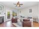 Bright living room featuring a fireplace, hardwood floors, and a door leading to the deck at 100 Stratford Lakes # 130, Durham, NC 27713