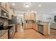 Spacious kitchen featuring stainless steel appliances, wooden cabinets, and an arched doorway at 105 Old Barn Way, Wendell, NC 27591