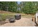 Paver patio with grill and fire pit, surrounded by a lush, wooded backyard at 105 Old Barn Way, Wendell, NC 27591