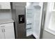 Stainless steel refrigerator with open door and kitchen area with white cabinets at 1110 Elmira Ave, Durham, NC 27707