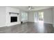 Living area with white brick fireplace, sliding door to patio, and wood flooring at 1110 Elmira Ave, Durham, NC 27707