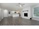 Open living room with white brick fireplace, kitchen, and wood flooring at 1110 Elmira Ave, Durham, NC 27707