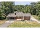 Birds eye view of the red brick house featuring a carport, and a large front yard surrounded by woods at 112 S Joyland St, Durham, NC 27703
