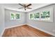 Bedroom with hardwood floors, a ceiling fan and three windows at 112 S Joyland St, Durham, NC 27703