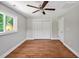 Bedroom with hardwood floors, ceiling fan and light fixture, a window and closet at 112 S Joyland St, Durham, NC 27703