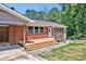 Close-up of a brick home showing the front porch, carport, and fresh landscaping at 112 S Joyland St, Durham, NC 27703