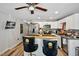 This kitchen includes white cabinets, an island with seating, stainless steel appliances, and a TV on the wall at 112 S Joyland St, Durham, NC 27703