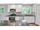 Updated kitchen featuring granite countertops, stainless steel appliances, tile backsplash, and white cabinets at 112 S Joyland St, Durham, NC 27703