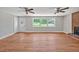 Spacious living room with hardwood floors, a brick fireplace, and abundant natural light from a large window at 112 S Joyland St, Durham, NC 27703