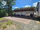 A covered patio features brick flooring, outdoor seating, stacked firewood, and an RV parked nearby at 112 S Joyland St, Durham, NC 27703