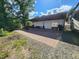 Covered brick patio with outdoor seating, fire pit, firewood, and RV nearby at 112 S Joyland St, Durham, NC 27703