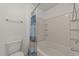 Tiled bathtub with shower, toilet, and storage shelves at 1120 Renewal Pl # 111, Raleigh, NC 27603
