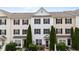 Attractive townhome exterior with symmetrical landscaping, dark shutters, and a charming covered front porch at 1120 Renewal Pl # 111, Raleigh, NC 27603