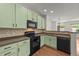 Updated kitchen featuring modern appliances, tile backsplash, and wooden floors at 1120 Renewal Pl # 111, Raleigh, NC 27603
