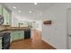 Open kitchen area with black appliances, hardwood floors, and view to the living room at 1120 Renewal Pl # 111, Raleigh, NC 27603