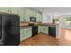 Well-equipped kitchen with black appliances, ample counter space, and light green cabinets at 1120 Renewal Pl # 111, Raleigh, NC 27603