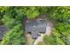 Aerial view of a house with a long driveway and a fenced-in pool area, all surrounded by mature trees at 1134 Deerfoot Trail Trl, Sanford, NC 27332
