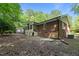 View of brick house from a leaf strewn backyard featuring brick and wood exterior and lawn at 1134 Deerfoot Trail Trl, Sanford, NC 27332