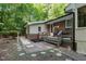 Charming backyard with patio, wood deck, walkway, and wooded backdrop at 1134 Deerfoot Trail Trl, Sanford, NC 27332