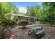 Backyard with picnic table surrounded by mature trees and a brick house at 1134 Deerfoot Trail Trl, Sanford, NC 27332