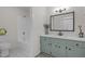 Bathroom featuring tub/shower, framed mirror and green vanity with modern fixtures at 1134 Deerfoot Trail Trl, Sanford, NC 27332