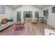 Open-concept living room area showcasing wood floors, stylish furniture, and an adjoining sun room at 1134 Deerfoot Trail Trl, Sanford, NC 27332