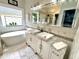 Bright bathroom with double sink vanity, large mirror and soaking tub under a window at 121 Chimney Rise Dr, Cary, NC 27511