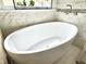 Soaking tub situated next to a window with modern fixtures at 121 Chimney Rise Dr, Cary, NC 27511