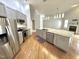 Open kitchen with granite counters, island sink, stainless appliances, hardwood floors and modern lighting at 121 Chimney Rise Dr, Cary, NC 27511