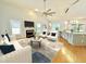 Bright, open living room with fireplace, large ceiling fan, and view to the adjacent eat-in kitchen at 121 Chimney Rise Dr, Cary, NC 27511