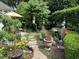 Lush backyard garden features stone path, water feature, and mature landscaping at 12221 Orchardgrass Ln, Raleigh, NC 27614