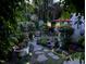Enchanting backyard garden at twilight, featuring stone pathways, lush plantings, and ambient lighting at 12221 Orchardgrass Ln, Raleigh, NC 27614