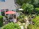 Outdoor living space featuring a stone patio, lush garden beds, and tranquil landscaping at 12221 Orchardgrass Ln, Raleigh, NC 27614