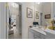 Hall bathroom with tile floors, white vanity, and framed mirror at 12221 Orchardgrass Ln, Raleigh, NC 27614