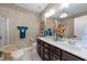 Lovely bathroom featuring dual sinks, dark cabinets, and gorgeous lighting fixtures at 12221 Orchardgrass Ln, Raleigh, NC 27614