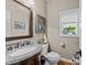 Charming powder room with granite countertop, decorative mirror, and window at 12221 Orchardgrass Ln, Raleigh, NC 27614
