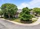 Charming brick home featuring mature landscaping, a well-manicured lawn, and a welcoming front porch at 12221 Orchardgrass Ln, Raleigh, NC 27614